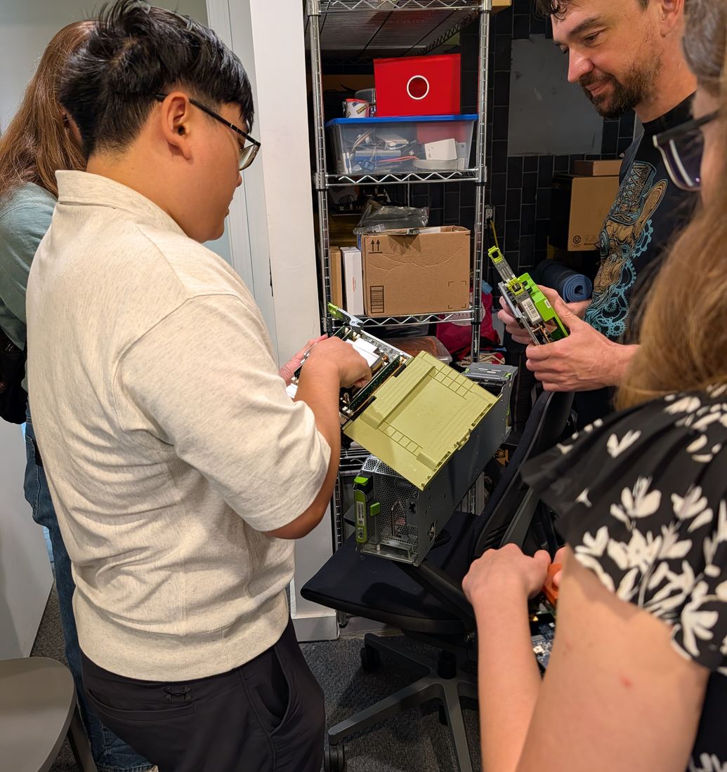 Howie pulls a board out of an OCP server sled while Roman holds another module