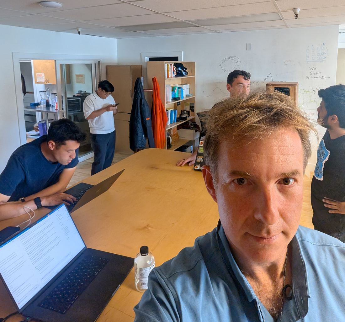The lab's main room with people at laptops around a long wooden table, Yaroslav in front