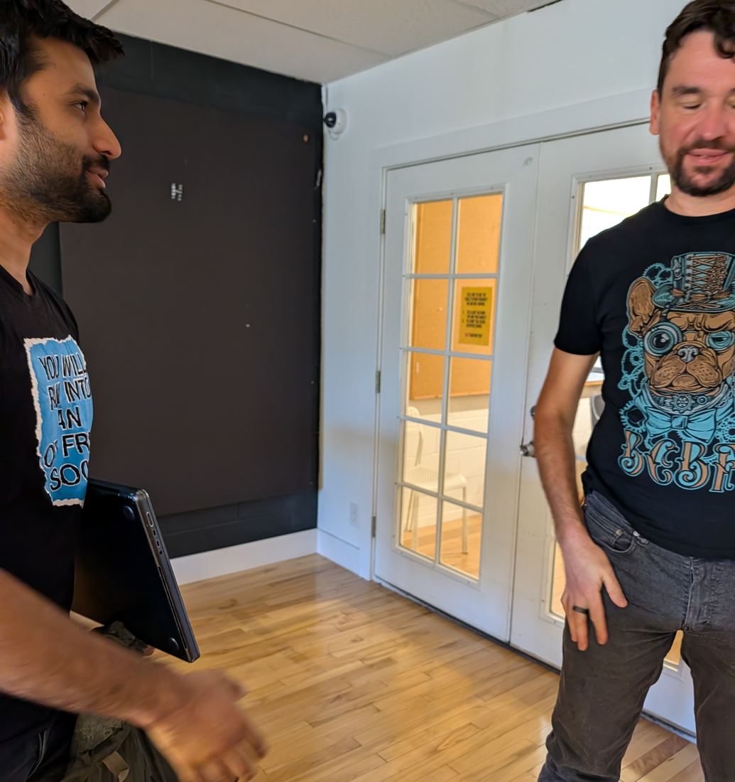 Daanish and Roman talking by the lab's glass doors