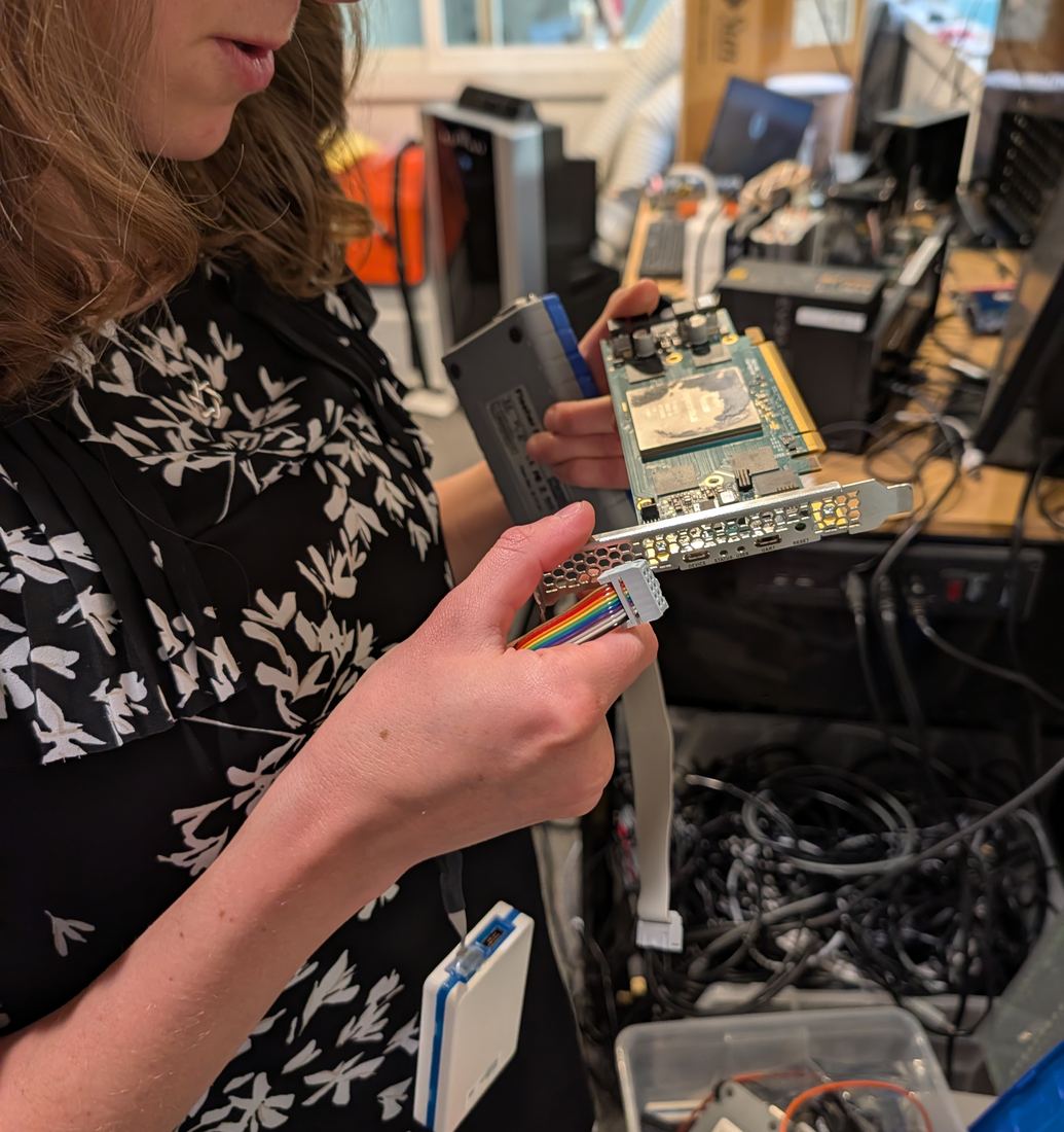 Tanya holds a card with a programming cable attached